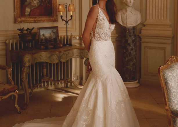 Bride in a fitted trumpet wedding dress with a lace bodice and flared skirt in a classic interior