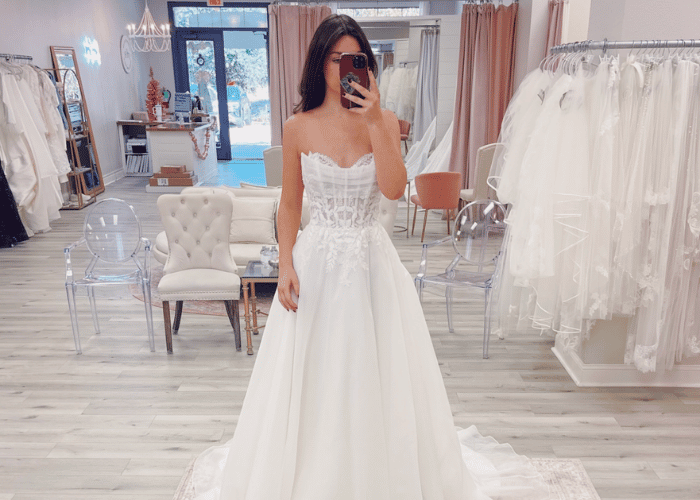 Bride trying on a corset bodice A-line wedding dress during a bridal boutique appointment