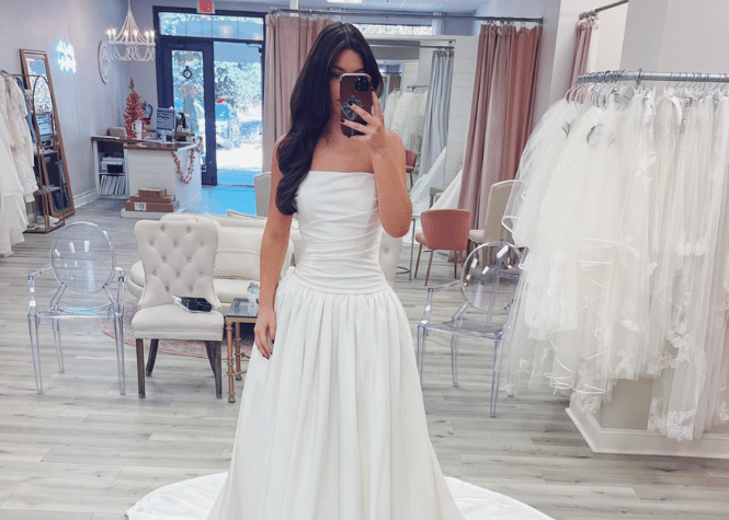 Bride trying on minimalist wedding dress in bridal boutique