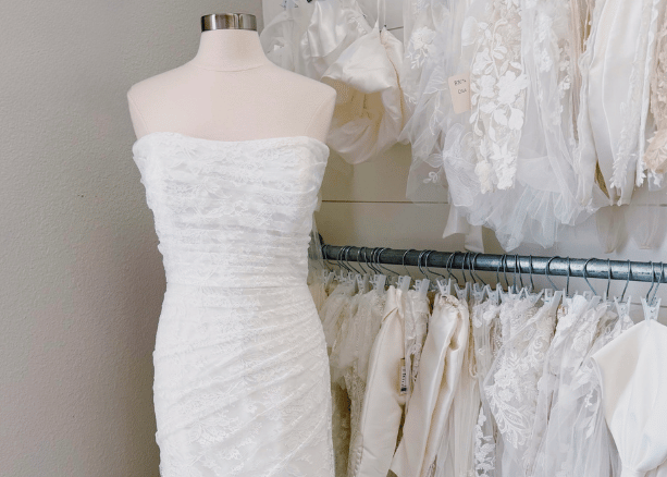 Olivier Couture bridal boutique reception area with a pink sofa, floral artwork, and elegant decor.