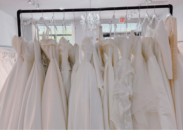 Collection of white wedding dresses displayed on a boutique clothing rack