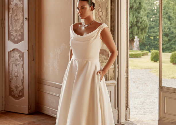Bride wearing a classic A-line wedding dress with a cowl neckline indoors