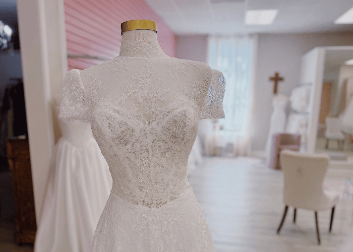 Lace wedding dress displayed in a bridal boutique before wedding dress shopping