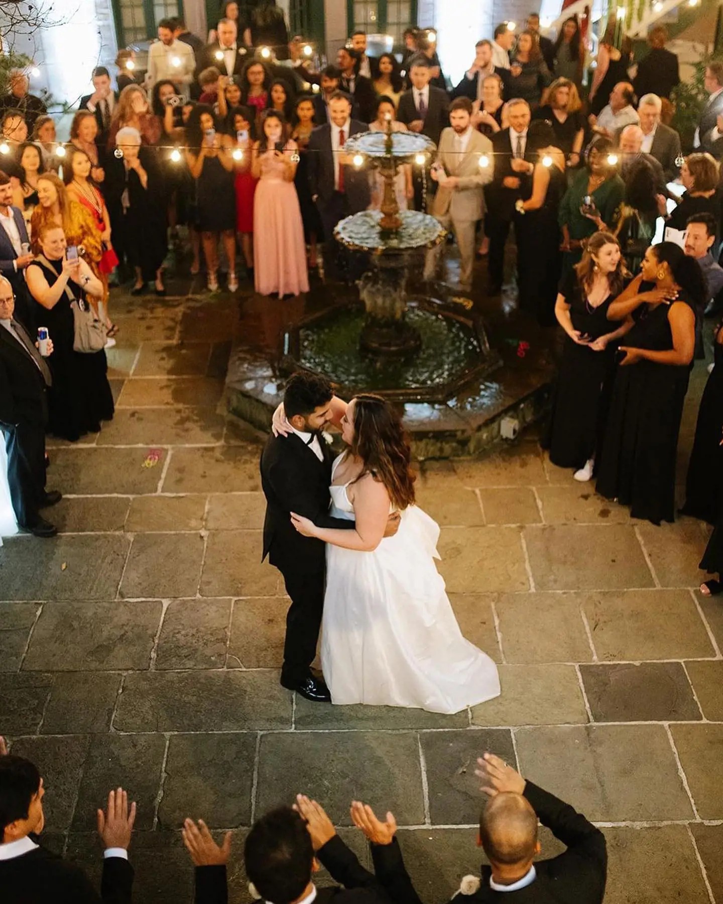 Photo of a real bride and groom dancing near fountain