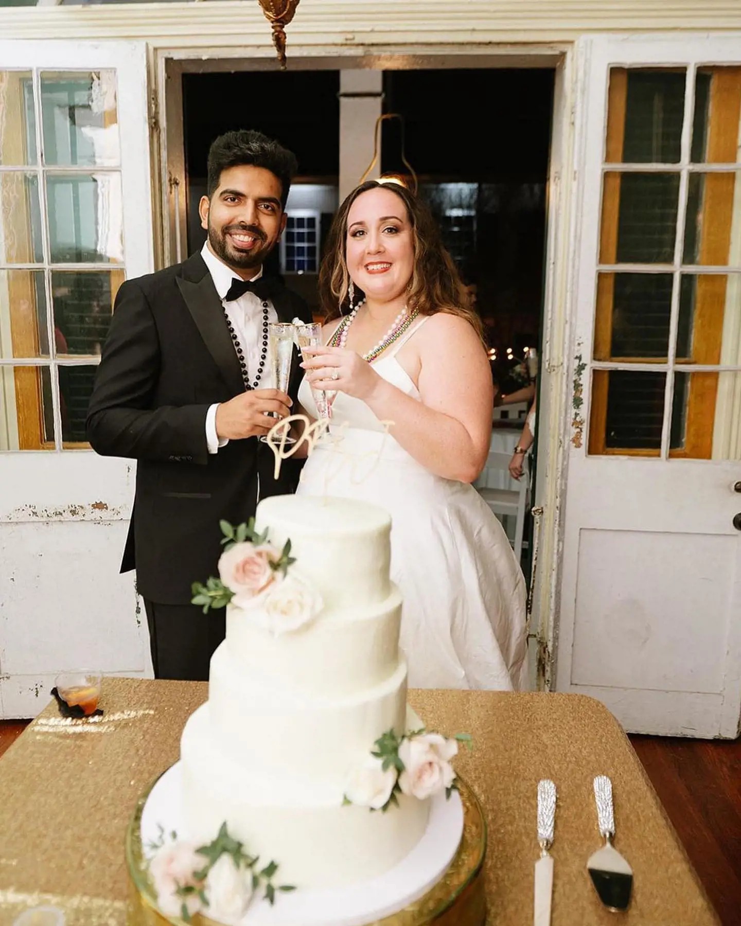 Photo of the real bride and groom next to the cake