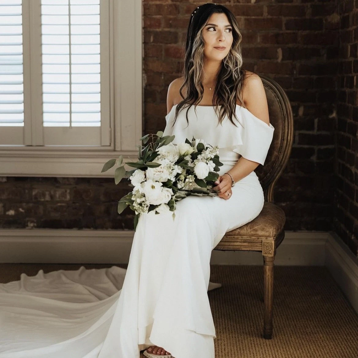 Real bride in a white long bridal gown, holding her flower bouquet